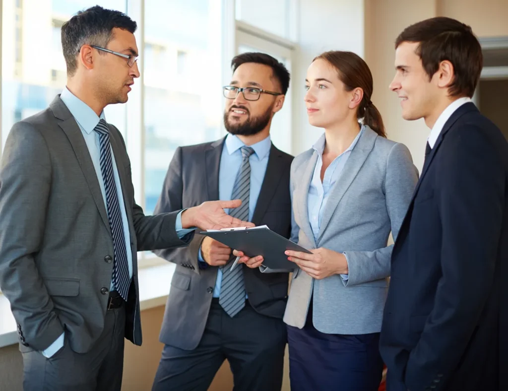 A business owner talking with three team members