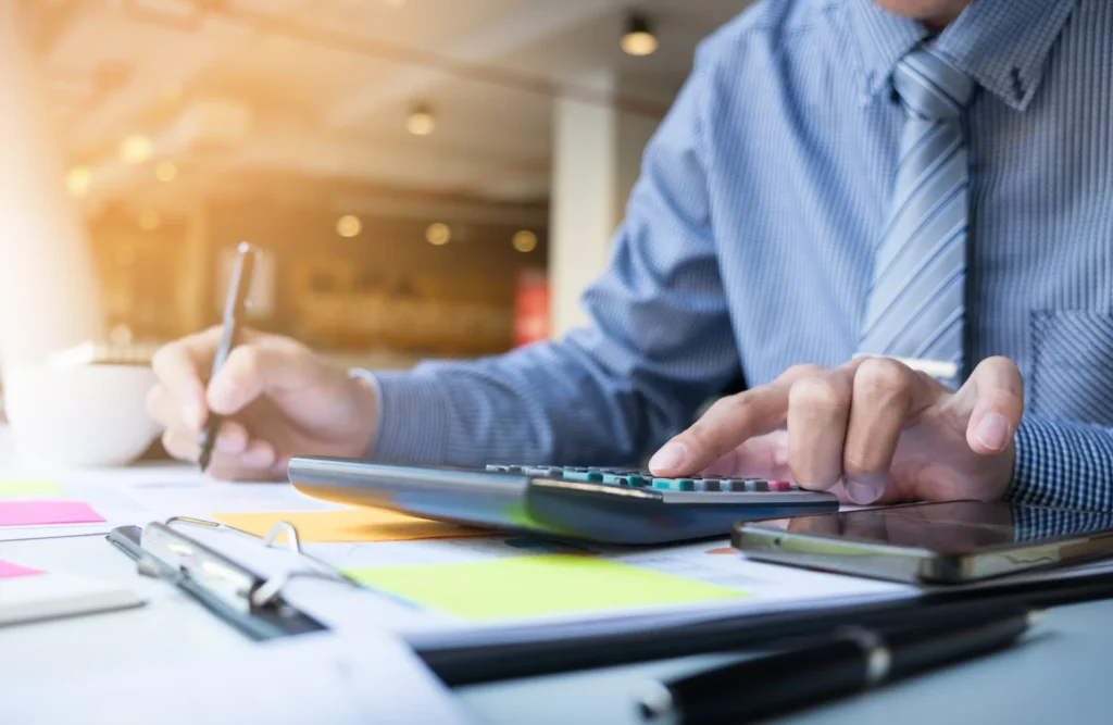 Tax preparer working through figures on a calculator
