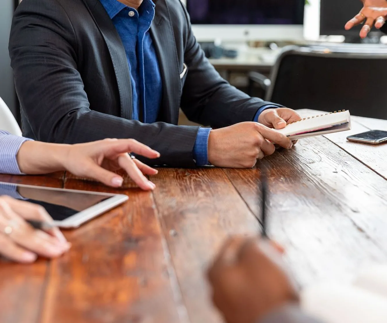 Hands of a team working through paperwork at a table